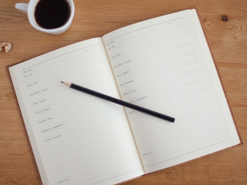 Cuaderno y plan de trabajo junto a una taza de café